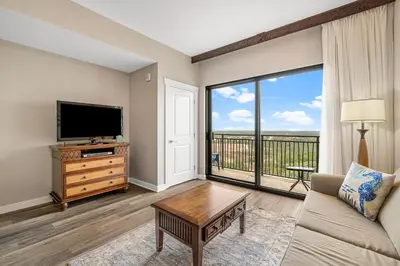 a living room with a flat screen tv and a couch at Origin 1313 - Studio King - Amazing Value - Cozy Unit by Beach Haven Vacation Rentals in Panama City Beach