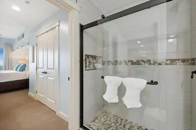 a bathroom with a shower with white towels at Origin 1231 - One Bedroom - Sunrise and Gulf Views by Beach Haven Vacation Rentals in Panama City Beach