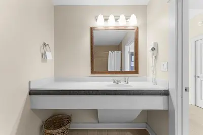 a white bathroom with a sink and a mirror at Origin 1220 - Studio King - Gulf View by Beach Haven Vacation Rentals in Panama City Beach