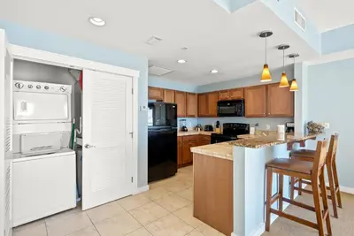 a kitchen with white appliances and wooden cabinets at Origin 1216 - One Bedroom - Breath Taking Gulf Views by Beach Haven Vacation Rentals in Panama City Beach