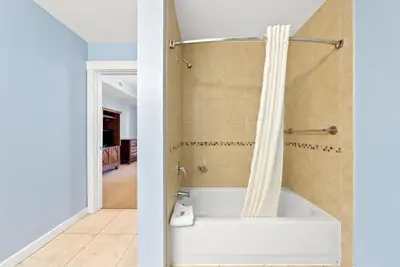 a bath tub with a shower curtain in a bathroom at Origin 1216 - One Bedroom - Breath Taking Gulf Views by Beach Haven Vacation Rentals in Panama City Beach