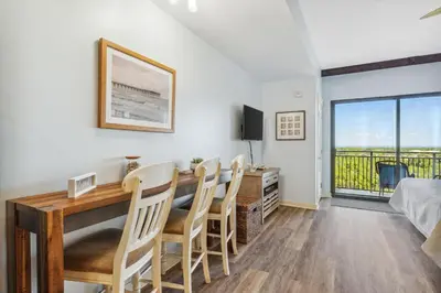 a living room with a dining room table and chairs at Origin 1213 - Studio King - Amazing Value by Beach Haven Vacation Rentals in Panama City Beach