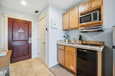 a kitchen with a sink and a microwave at Origin 1213 - Studio King - Amazing Value by Beach Haven Vacation Rentals in Panama City Beach