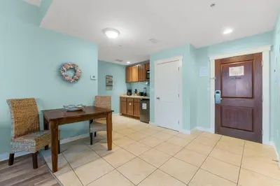 a dining room with a table and chairs and a kitchen at Origin 1129 - Studio King Gulf View - Partial Gulf View by Beach Haven Vacation Rentals in Panama City Beach