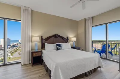 a bedroom with a large bed and large windows at Origin 1111 - One Bedroom - Cozy Partial Gulf View by Beach Haven Vacation Rentals in Panama City Beach