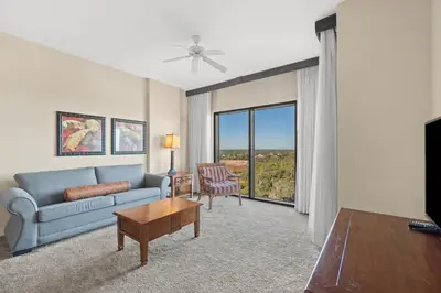 a living room with a blue couch and a table at Origin 1027 - One Bedroom - Nature and Partial Gulf Views by Beach Haven Vacation Rentals in Panama City Beach