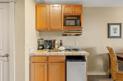 a small kitchen with a sink and a microwave at Origin 1023 - Studio King - Peaceful Nature View Unit by Beach Haven Vacation Rentals in Panama City Beach