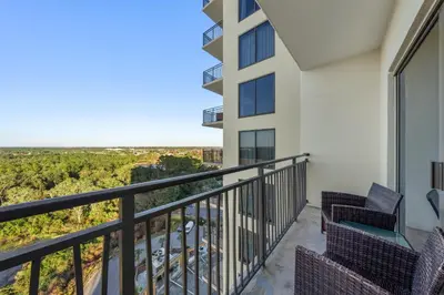 a balcony with chairs and a view of the desert at Origin 1013 - Studio King - Peaceful Nature View by Beach Haven Vacation Rentals in Panama City Beach