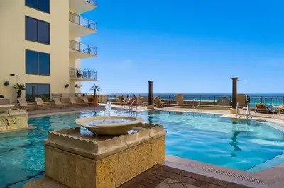 a swimming pool with a fountain in front of a building at Origin 1007 - One Bedroom - Sunset View by Beach Haven Vacation Rentals in Panama City Beach