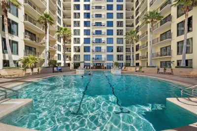 a swimming pool in front of a large apartment building at Origin 0915 - Studio King - Cozy Nature View by Beach Haven Vacation Rentals in Panama City Beach