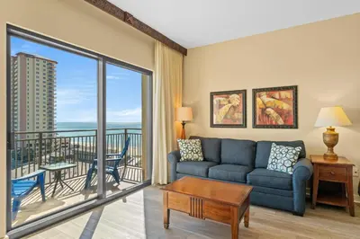 a living room with a couch and a view of the ocean at Origin 0833 - Studio King - Sunrise & Gulf View by Beach Haven Vacation Rentals in Panama City Beach