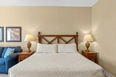 a bedroom with a bed and a blue couch at Origin 0833 - Studio King - Sunrise & Gulf View by Beach Haven Vacation Rentals in Panama City Beach