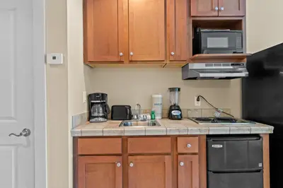 a small kitchen with a sink and a microwave at Origin 0833 - Studio King - Sunrise & Gulf View by Beach Haven Vacation Rentals in Panama City Beach