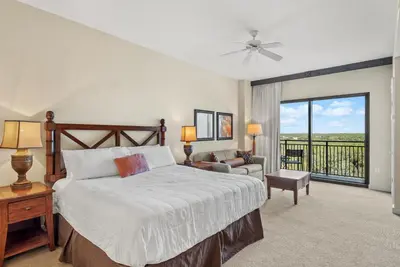 a bedroom with a bed and a balcony at Origin 0815 - Studio King - Peaceful Nature View by Beach Haven Vacation Rentals in Panama City Beach