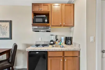 a small kitchen with a sink and a microwave at Origin 0815 - Studio King - Peaceful Nature View by Beach Haven Vacation Rentals in Panama City Beach