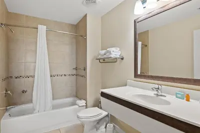 a bathroom with a sink and a toilet and a mirror at Origin 0815 - Studio King - Peaceful Nature View by Beach Haven Vacation Rentals in Panama City Beach