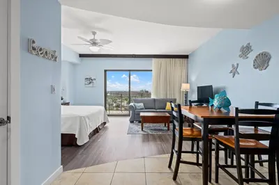 a bedroom with a bed and a dining room with a table at Origin 0729 - Studio King - Sunrise Gulf View by Beach Haven Vacation Rentals in Panama City Beach