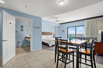 a living room with a dining room table and a bedroom at Origin 0729 - Studio King - Sunrise Gulf View by Beach Haven Vacation Rentals in Panama City Beach
