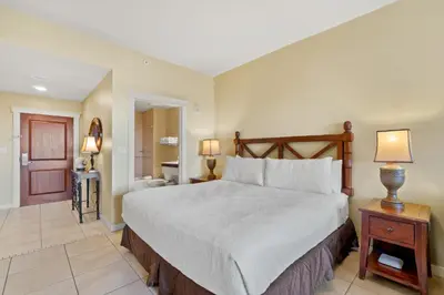 a bedroom with a large bed and a bathroom at Origin 0715 - Studio King - Quiet Nature View Unit by Beach Haven Vacation Rentals in Panama City Beach