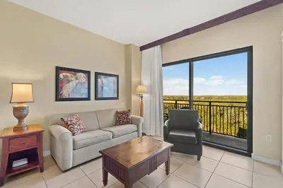 a living room with a couch and a chair at Origin 0715 - Studio King - Quiet Nature View Unit by Beach Haven Vacation Rentals in Panama City Beach