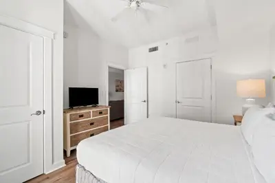 a white bedroom with a bed and a tv at Origin 0708 - One Bedroom - Pool and Gulf Views by Beach Haven Vacation Rentals in Panama City Beach