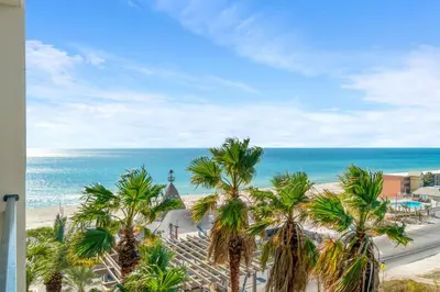 a view of a beach with palm trees and the ocean at Origin 0707 - One Bedroom - Stunning Sunset Views by Beach Haven Vacation Rentals in Panama City Beach