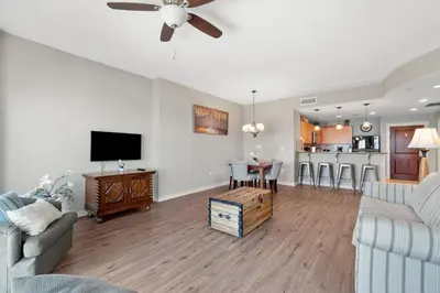 a living room with a couch and a tv and a table at Origin 0707 - One Bedroom - Stunning Sunset Views by Beach Haven Vacation Rentals in Panama City Beach
