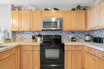 a kitchen with a black stove and a microwave at Origin 0707 - One Bedroom - Stunning Sunset Views by Beach Haven Vacation Rentals in Panama City Beach