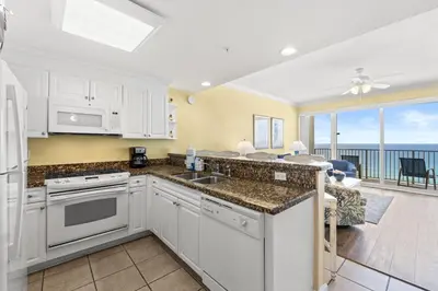 a kitchen with white cabinets and a view of the ocean at Boardwalk Beach Resort #1107 by Book That Condo in Panama City Beach