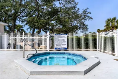 a swimming pool in front of a white fence at The Love Shack (2/2) in Panama City Beach