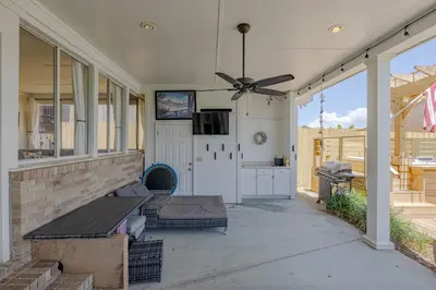a screened porch with a ceiling fan and a kitchen at Boat dock and jet ski pad! bring your boat! in Panama City Beach