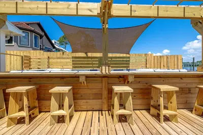 a wooden deck with a bar with stools at Boat dock and jet ski pad! bring your boat! in Panama City Beach