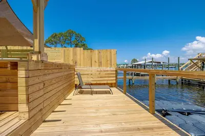a wooden dock with a chair on the water at Boat dock and jet ski pad! bring your boat! in Panama City Beach