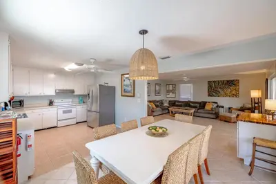 a kitchen and living room with a white table and chairs at Boat dock and jet ski pad! bring your boat! in Panama City Beach