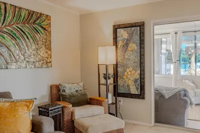 a living room with a chair and a mirror at Boat dock and jet ski pad! bring your boat! in Panama City Beach