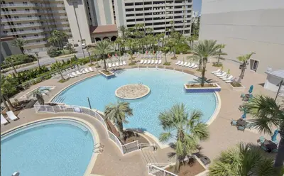 an overhead view of a large swimming pool with chairs and palm trees at Laketown - Top Floor! Amazing Views! in Panama City Beach