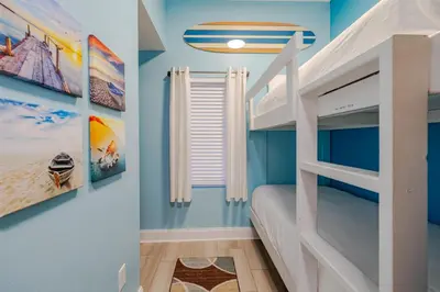 a childs bedroom with blue walls and bunk beds at Laketown - Top Floor! Amazing Views! in Panama City Beach