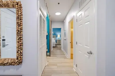 a hallway with a white door and a mirror at Laketown - Top Floor! Amazing Views! in Panama City Beach