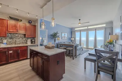 a kitchen and dining room with a view of the ocean at Laketown - Top Floor! Amazing Views! in Panama City Beach