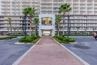 a street in front of a large building with palm trees at Laketown - Top Floor! Amazing Views! in Panama City Beach