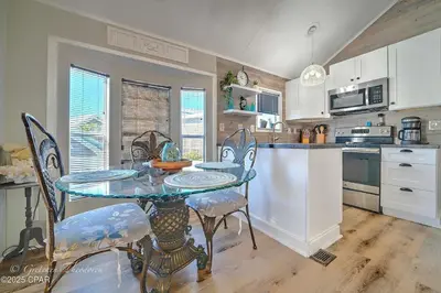 a kitchen with a glass table and chairs in it at Enjoy your quiet vacation at Butler's Beach Retreat! in Panama City Beach