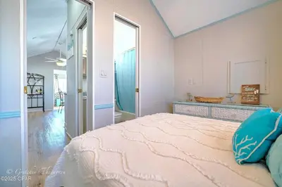 a bedroom with a large bed and a mirror at Enjoy your quiet vacation at Butler's Beach Retreat! in Panama City Beach