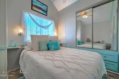 a bedroom with a bed with a large mirror at Enjoy your quiet vacation at Butler's Beach Retreat! in Panama City Beach