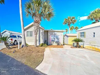 a house with a palm tree in a driveway at Enjoy your quiet vacation at Butler's Beach Retreat! in Panama City Beach