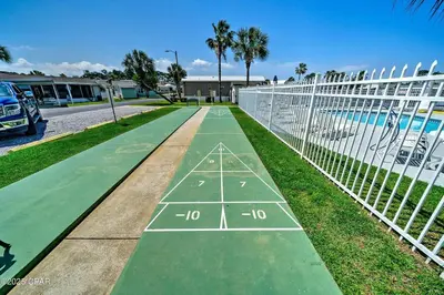 a tennis court on the grass next to a fence at Enjoy your quiet vacation at Butler's Beach Retreat! in Panama City Beach
