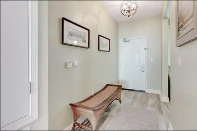 a hallway with a wooden bench on the wall at Aqua 403 - Free Beach Chairs! Indoor/Outdoor Pool! in Panama City Beach