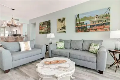 a living room with two couches and a table at Aqua 403 - Free Beach Chairs! Indoor/Outdoor Pool! in Panama City Beach