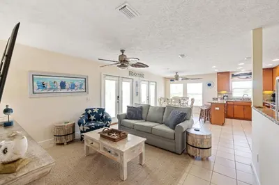 a living room with a couch and a table at New! Iguana Palms - Private beach - Pet Freindly! in Panama City Beach