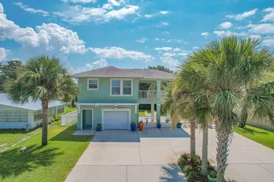 a house with palm trees in front of it at New! Iguana Palms - Private beach - Pet Freindly! in Panama City Beach