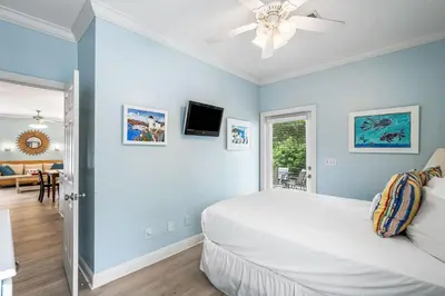 a bedroom with a white bed and a ceiling fan at Beach Bummin' - Week long stays get 4 free bikes rental! in Rosemary Beach